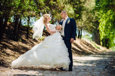 Açık havada bahar doğa üzerinde yürüme gün düğününde gelin ile damat. Gelin çift, mutlu yeni evli kadın ve yeşil park kucaklayan adam.