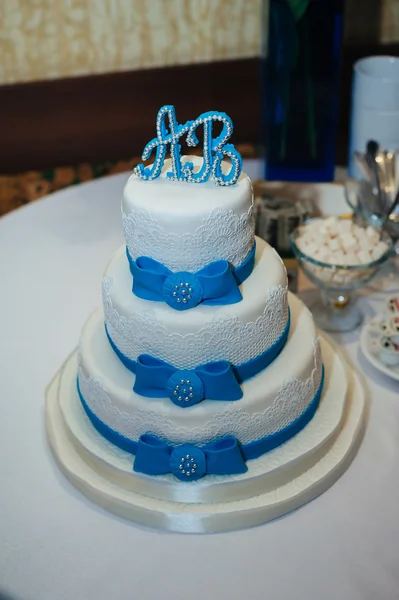 Bolo de casamento em combinação branca e azul, adornada com flores, fitas . — Fotografia de Stock