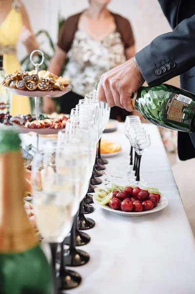 Meja dengan makanan dan minuman. Meja katering mengatur layanan dengan peralatan makan dan gelas stemware di restoran sebelum pesta — Stok Foto