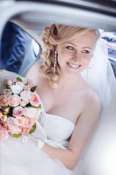 Portret van mooie vrouw in een auto. Close-up portret van vrij verlegen bruid op auto-venster — Stockfoto