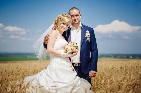 Nevěsta s ženichem na svatební den chůze venku na jarní přírody. Novomanželé, Happy novomanželský žena a muž objímal v parku. — Stock fotografie