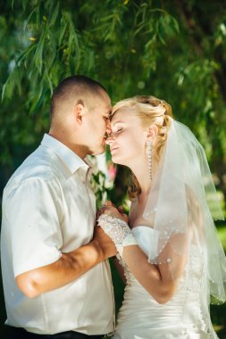 Açık havada bahar doğa üzerinde yürüme gün düğününde gelin ile damat. Gelin çift, mutlu yeni evli kadın ve yeşil park kucaklayan adam.