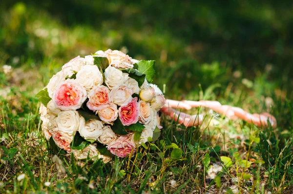 Beyaz düğün buketi yeşil çim üzerinde yalan — Stok fotoğraf