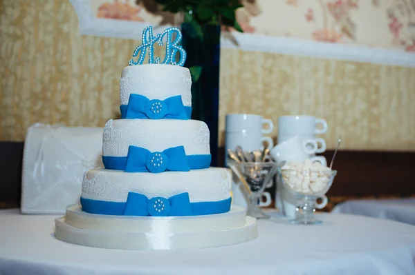 Wedding cake in white and blue combination, adorned with flowers, ribbons. — Stock Photo, Image