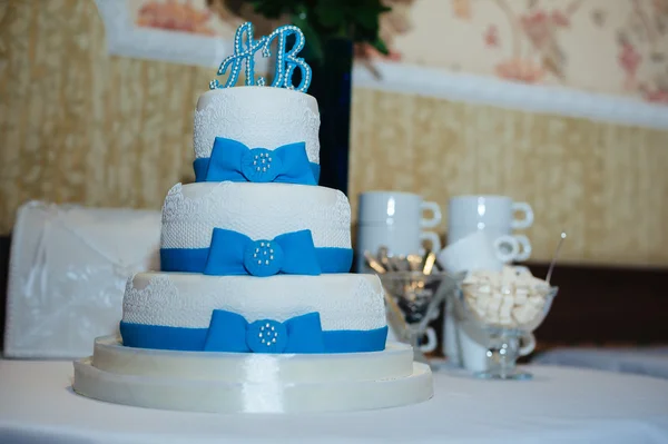 Bolo de casamento em combinação branca e azul, adornada com flores, fitas . — Fotografia de Stock