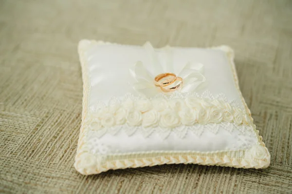 小さな白いクッションの上の黄金の結婚指輪 — ストック写真