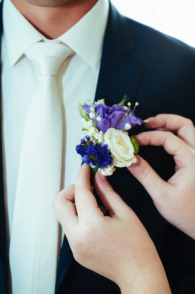 Χέρι νύφες βάζοντας το μπουτονιέρα λουλούδι για γαμπρό — Φωτογραφία Αρχείου