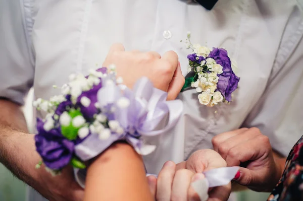 Brudar hand sätta boutonniere blomman på brudgummen — Stockfoto