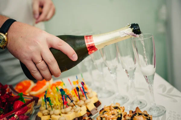 Pouring champagne into a glass on wedding celebration — Stock Photo, Image