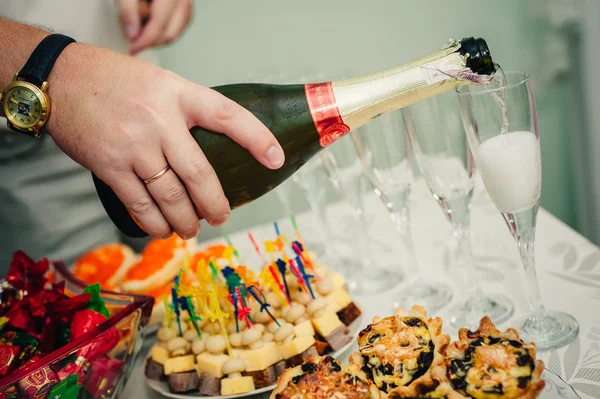 Hälla champagne i ett glas på bröllopsfesten — Stockfoto