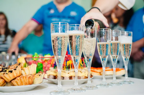 Pouring champagne into a glass on wedding celebration — Stock Photo, Image