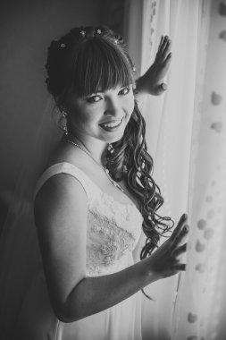 Genç güzel gelin damat pencerenin yanında bekler. Büyük pencere bekleyen yanında duran güzel genç kadın