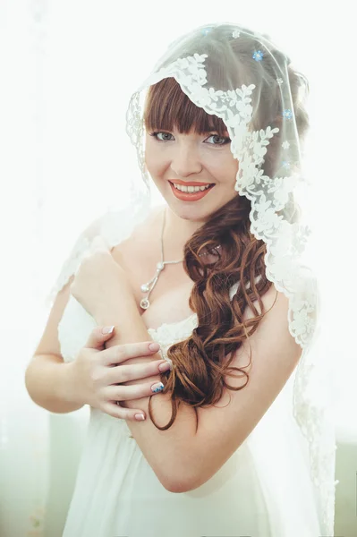 Jeune belle mariée attend marié près de la fenêtre. Belle jeune femme debout à côté d'une grande fenêtre qui attend — Photo