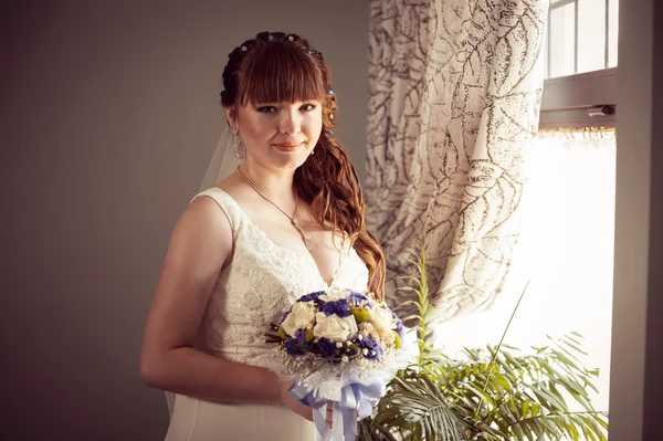 Bella giovane sposa in piedi accanto a una grande finestra in attesa — Foto Stock