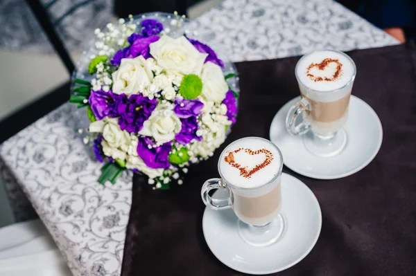 Dos tazas de café con el corazón en la mesa, ramo de boda nupcial . —  Fotos de Stock