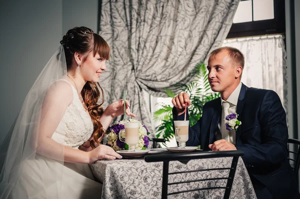 Sposo e sposo in lussuoso ristorante bere una tazza di caffè latte con design del cuore sul loro matrimonio o San Valentino data . — Foto Stock