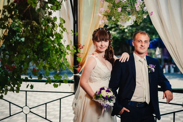 Jeunes mariés dans le parc, bouquet nuptial, robes de mariée — Photo