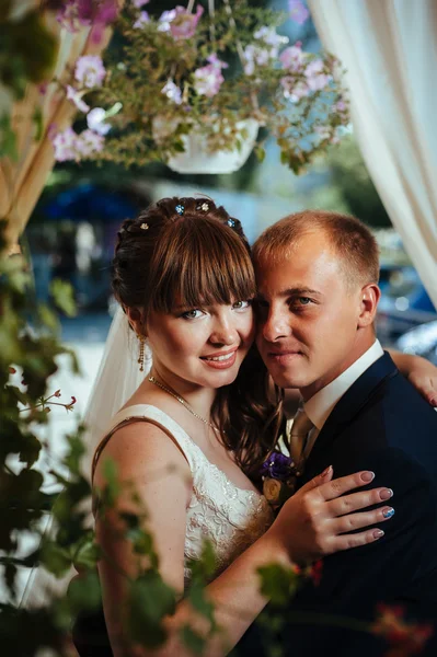 Jeunes mariés dans le parc, bouquet nuptial, robes de mariée — Photo