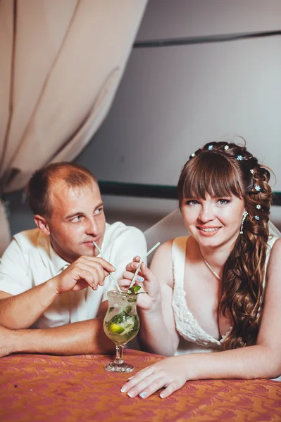 Bájos menyasszony és a vőlegény mojito inni a lakodalomban, egy luxus étterem. — Stock Fotó