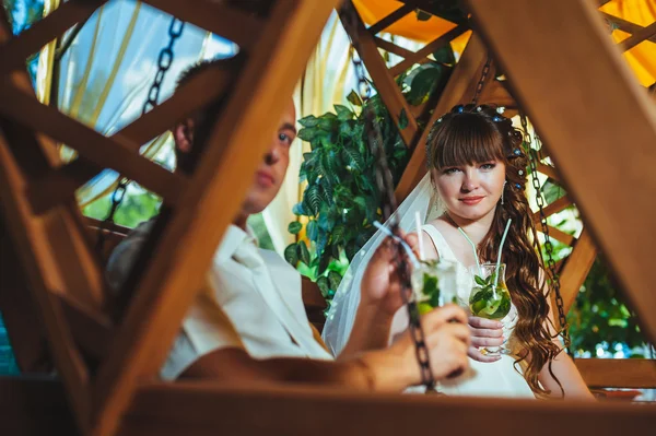 Happy bride and groom swinging on a swing — Stock Photo, Image