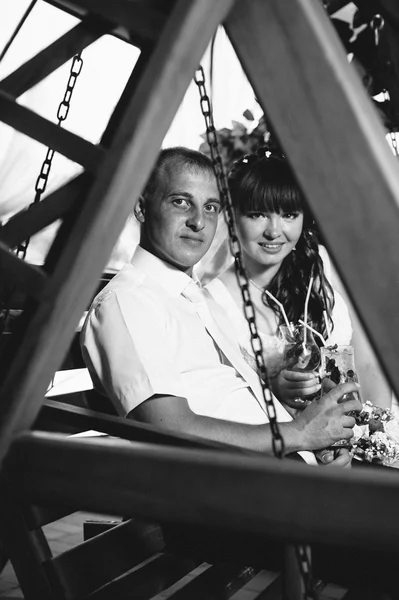 happy bride and groom swinging on a swing