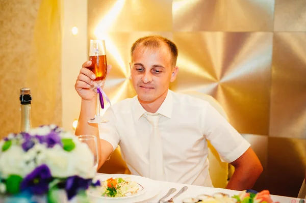 Jovem noivo no restaurante sentar-se à mesa do banquete — Fotografia de Stock