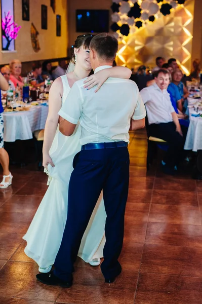 Baile de bodas de novios jóvenes en salón de banquetes. Beso, abrazo — Foto de Stock