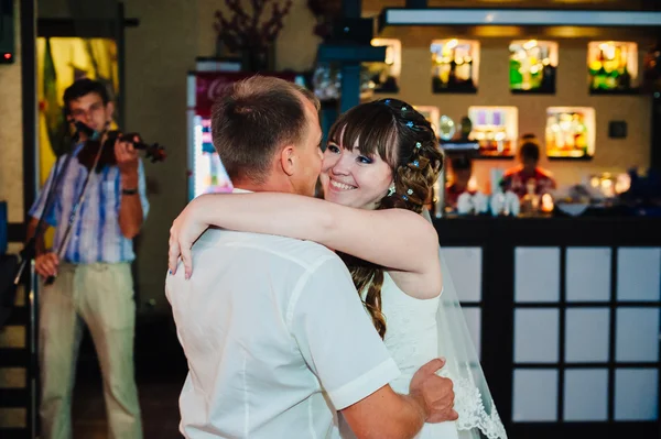 Dança de casamento de noiva jovem e noivo no salão de banquetes. Beijar, abraçar — Fotografia de Stock