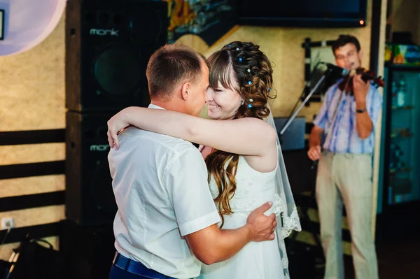 Baile de bodas de novios jóvenes en salón de banquetes. Beso, abrazo —  Fotos de Stock