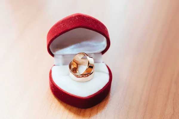 Anel de casamento em forma de coração caixa de presente vermelho no fundo arborizado . — Fotografia de Stock