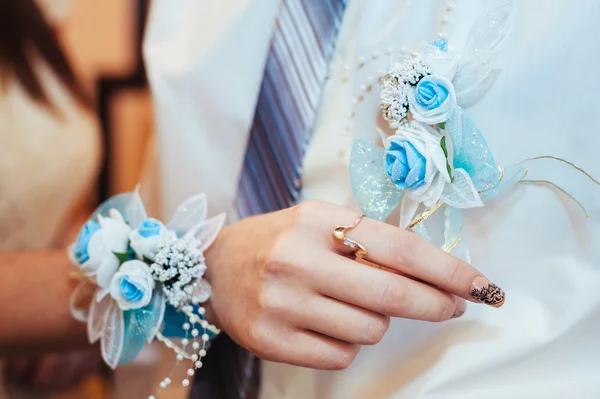 Mão de noivas pondo a flor boutonniere em um noivo — Fotografia de Stock