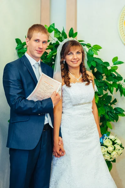 Az esküvői szertartás. Anyakönyvi hivatal. Az újonnan házas pár jelek a házasság dokumentum. — Stock Fotó