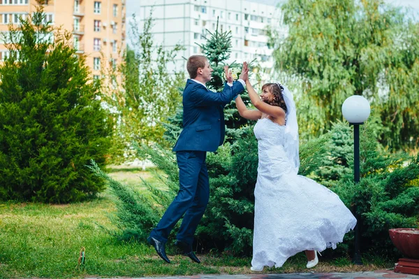 Bride and groom jumping in the air — Stock Photo, Image