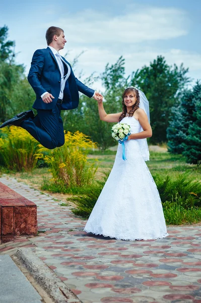 Жених и невеста прыгают в воздухе — стоковое фото
