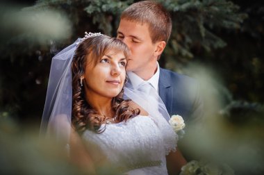 Gelin ve damat gün açık havada yürüyüş düğününde Doğa bahar. Gelin çift, mutlu yeni evli çift yeşil park kucaklayan.