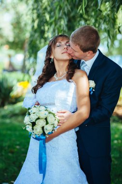 Gelin ve damat gün açık havada yürüyüş düğününde Doğa bahar. Gelin çift, mutlu yeni evli çift yeşil park kucaklayan.