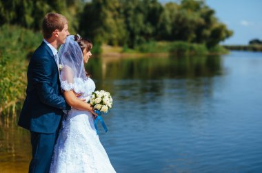 seven ayakta ve su kenarında öpüşme düğün Çift