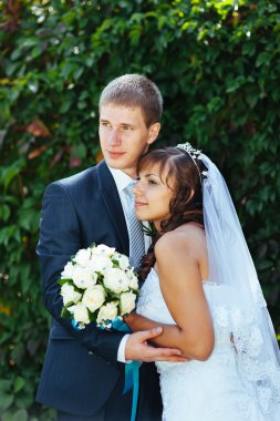 Gelin ve damat gün açık havada yürüyüş düğününde Doğa bahar. Gelin çift, mutlu yeni evli çift yeşil park kucaklayan.