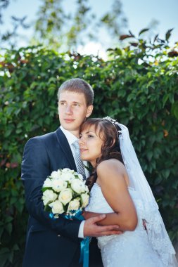 Gelin ve damat gün açık havada yürüyüş düğününde Doğa bahar. Gelin çift, mutlu yeni evli çift yeşil park kucaklayan.