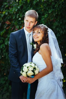 Gelin ve damat gün açık havada yürüyüş düğününde Doğa bahar. Gelin çift, mutlu yeni evli çift yeşil park kucaklayan.