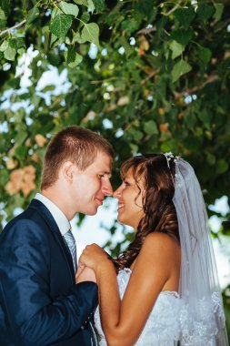 Gelin ve damat gün açık havada yürüyüş düğününde Doğa bahar. Gelin çift, mutlu yeni evli çift yeşil park kucaklayan.