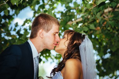 Gelin ve damat gün açık havada yürüyüş düğününde Doğa bahar. Gelin çift, mutlu yeni evli çift yeşil park kucaklayan.