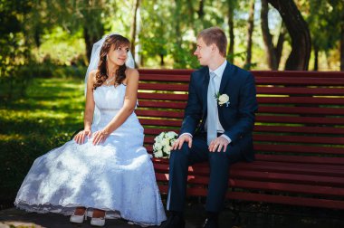 Gelin ve damat gün açık havada yürüyüş düğününde Doğa bahar. Gelin çift, mutlu yeni evli çift yeşil park kucaklayan.