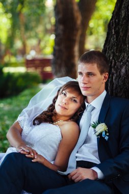 Gelin ve damat gün açık havada yürüyüş düğününde Doğa bahar. Gelin çift, mutlu yeni evli çift yeşil park kucaklayan.