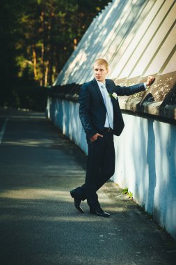 Düşünme ve onun papyon koyarak smokin mutlu yakışıklı beyaz damat.