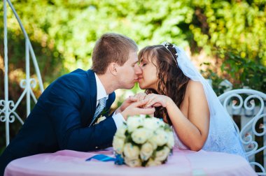 Gelin ve damat yaz parkta süslü ziyafet masada poz .