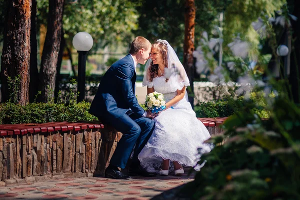 Bruden och brudgummen på bröllop dag promenader utomhus på vår natur. Brudparet, lycklig nygift par omfattar i grön park. — Stockfoto