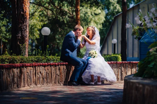 Menyasszony és a vőlegény az esküvő nap séta kint a tavaszi természet. Nászutas pár, boldog Newlywed pár átfogó zöld park. — Stock Fotó