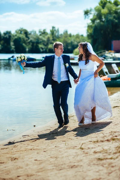 Milující Svatební pár stojící a líbání u vody — Stock fotografie