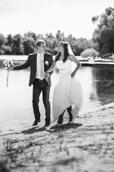 Amor casamento casal de pé e beijando perto da água — Fotografia de Stock